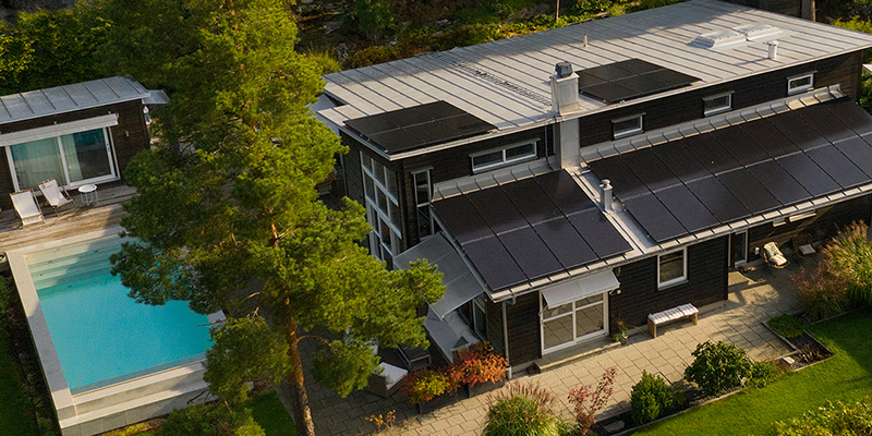 Hus med svarta solceller monterade på taket.
