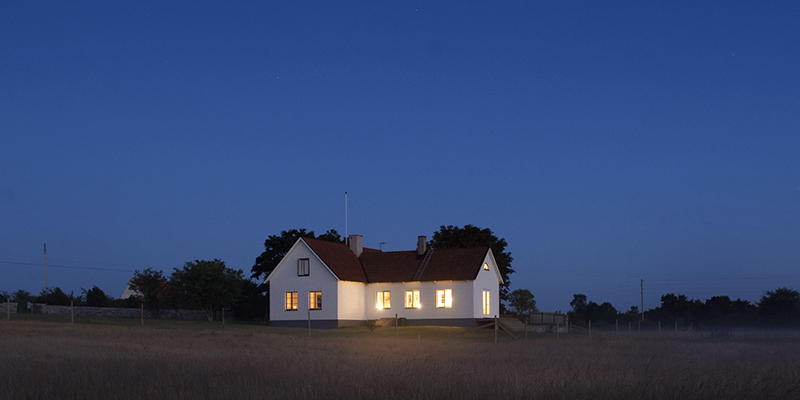 Ett hus med upplysta fönster och mörk himmel.