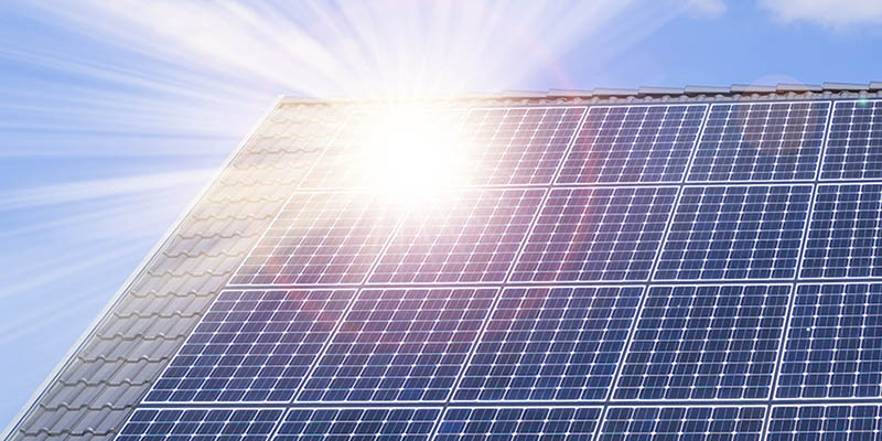 Gassande solsken på solceller på ett villatak.